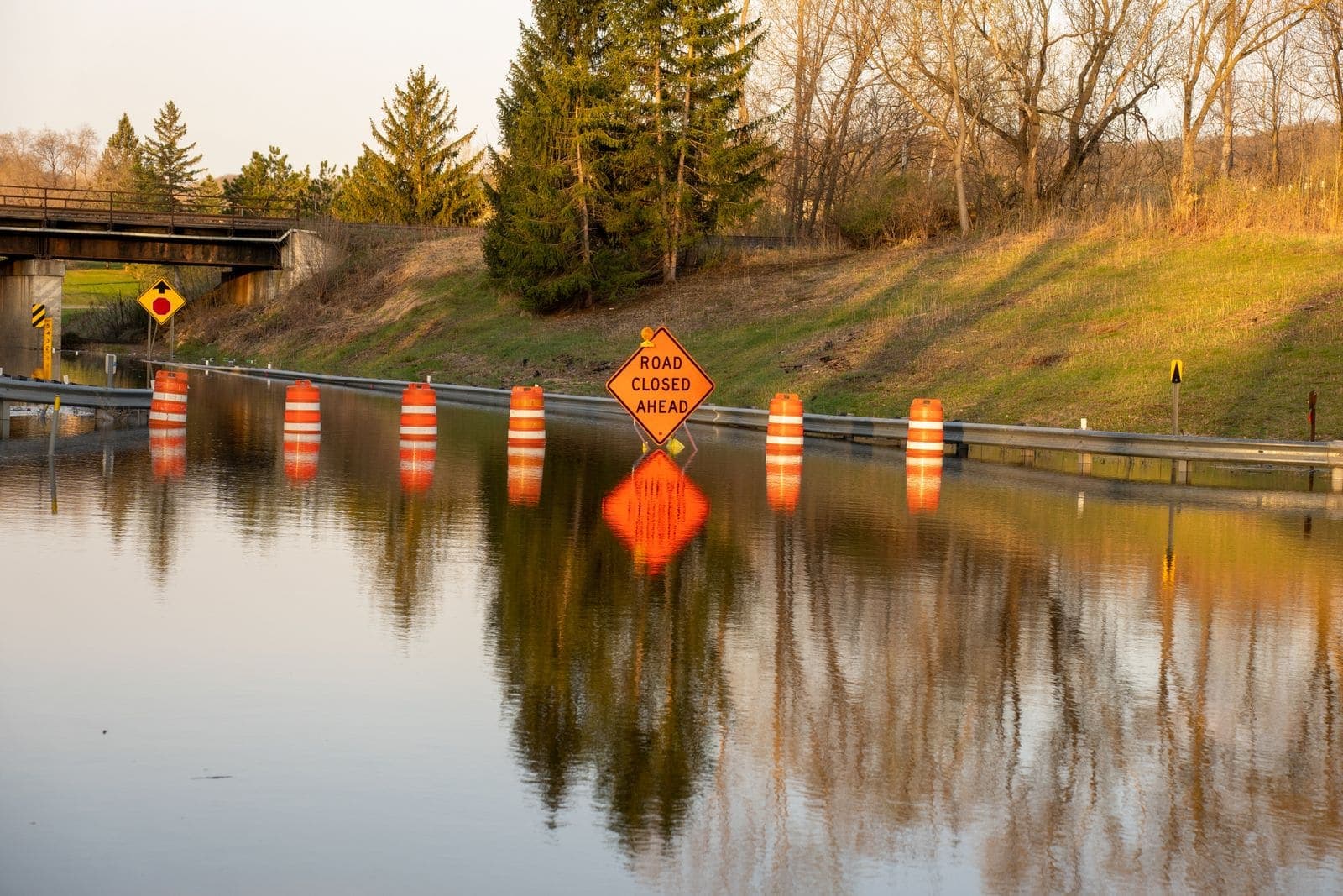 Flooded road with warning signs and barricades