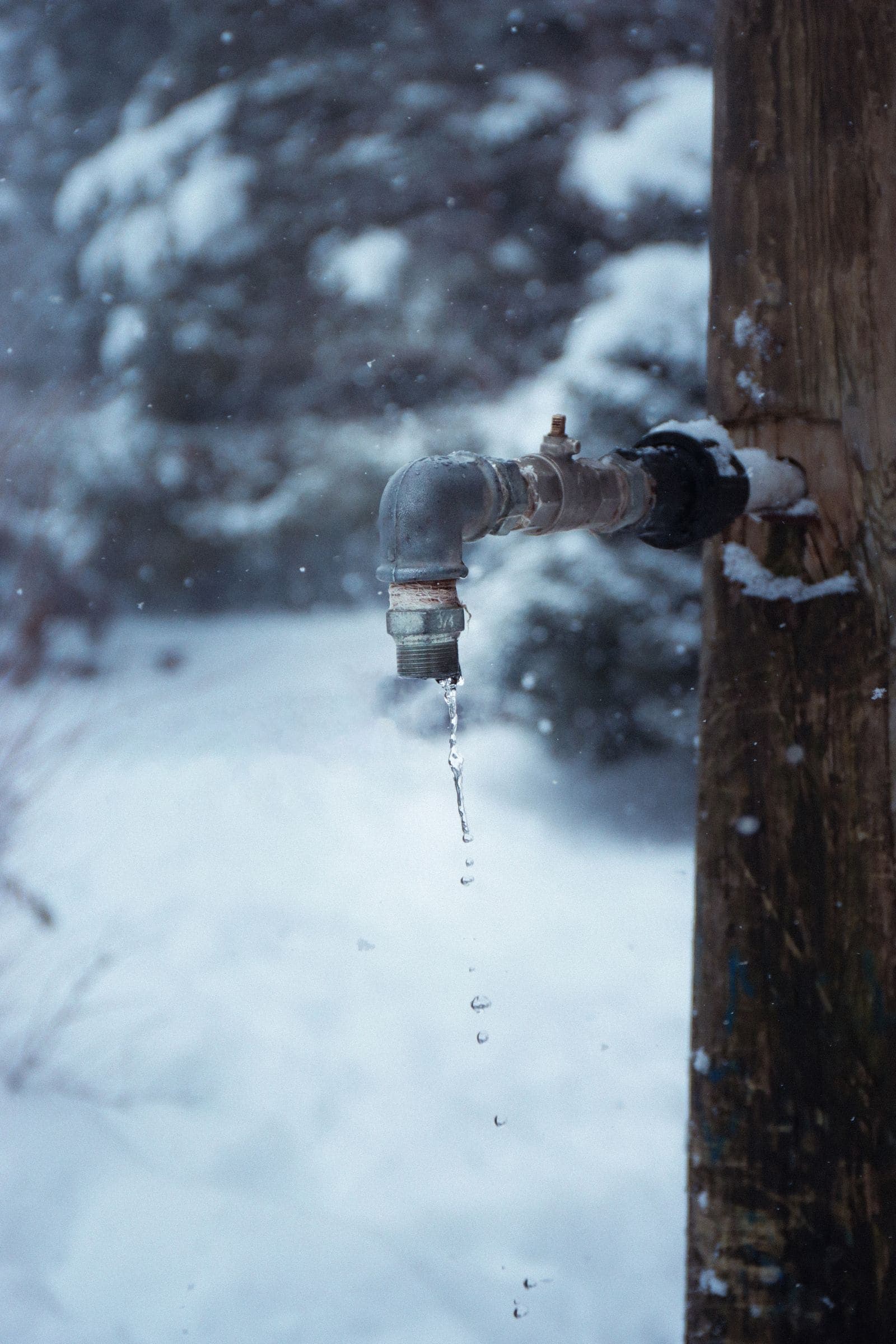 Outdoor faucet dripping in freezing winter weather