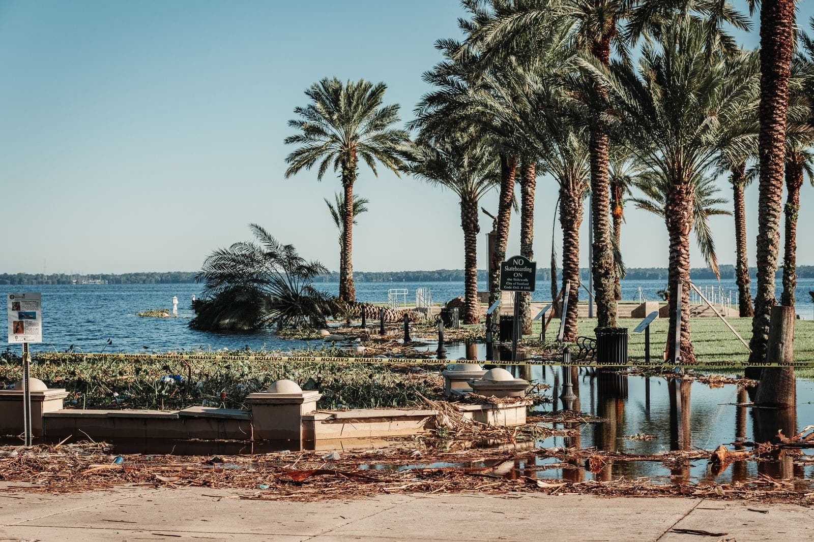 Storm debris and standing water along a Florida waterfront after a hurricane