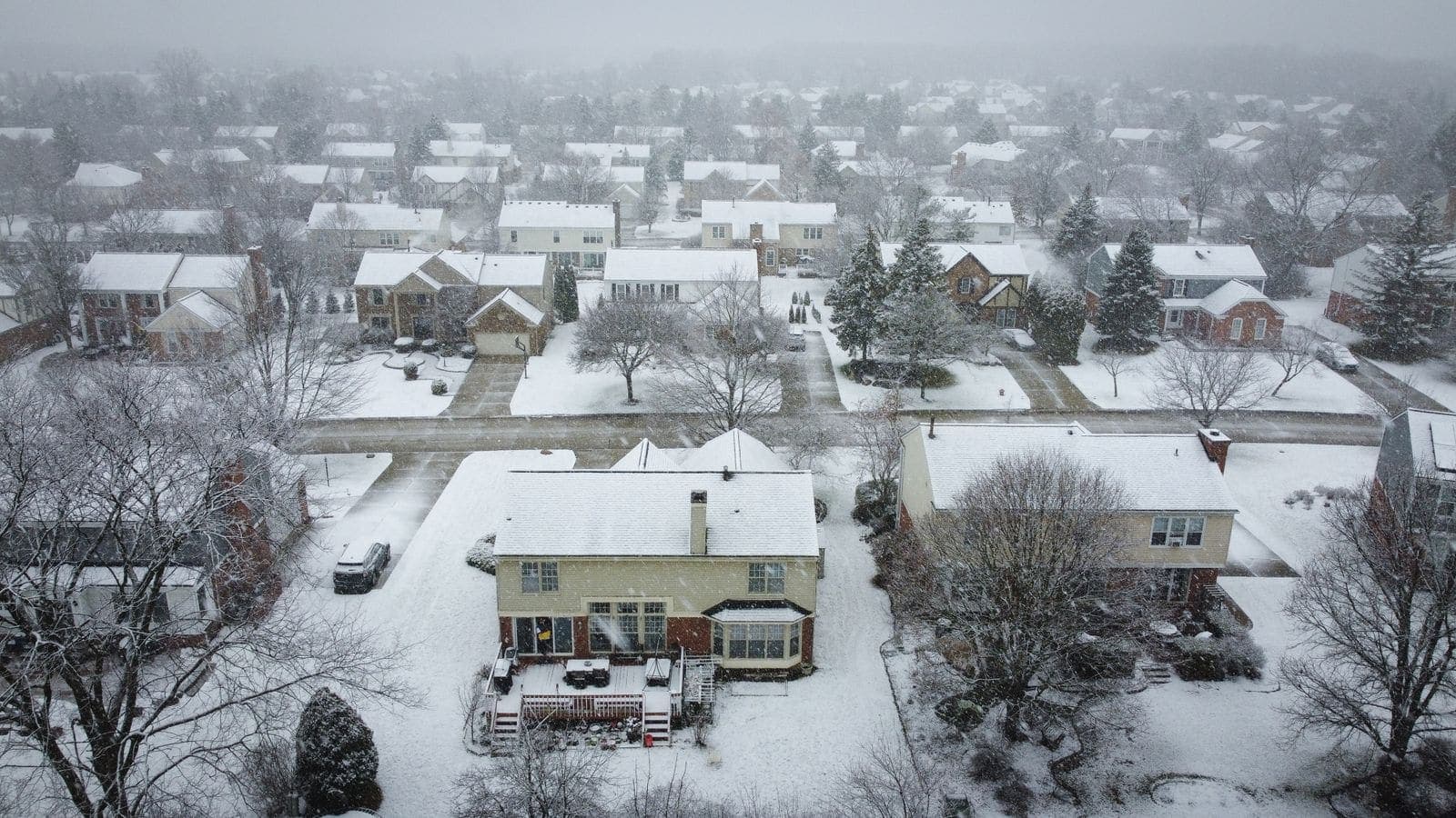 Aerial view of a snow-covered suburban neighborhood in winter