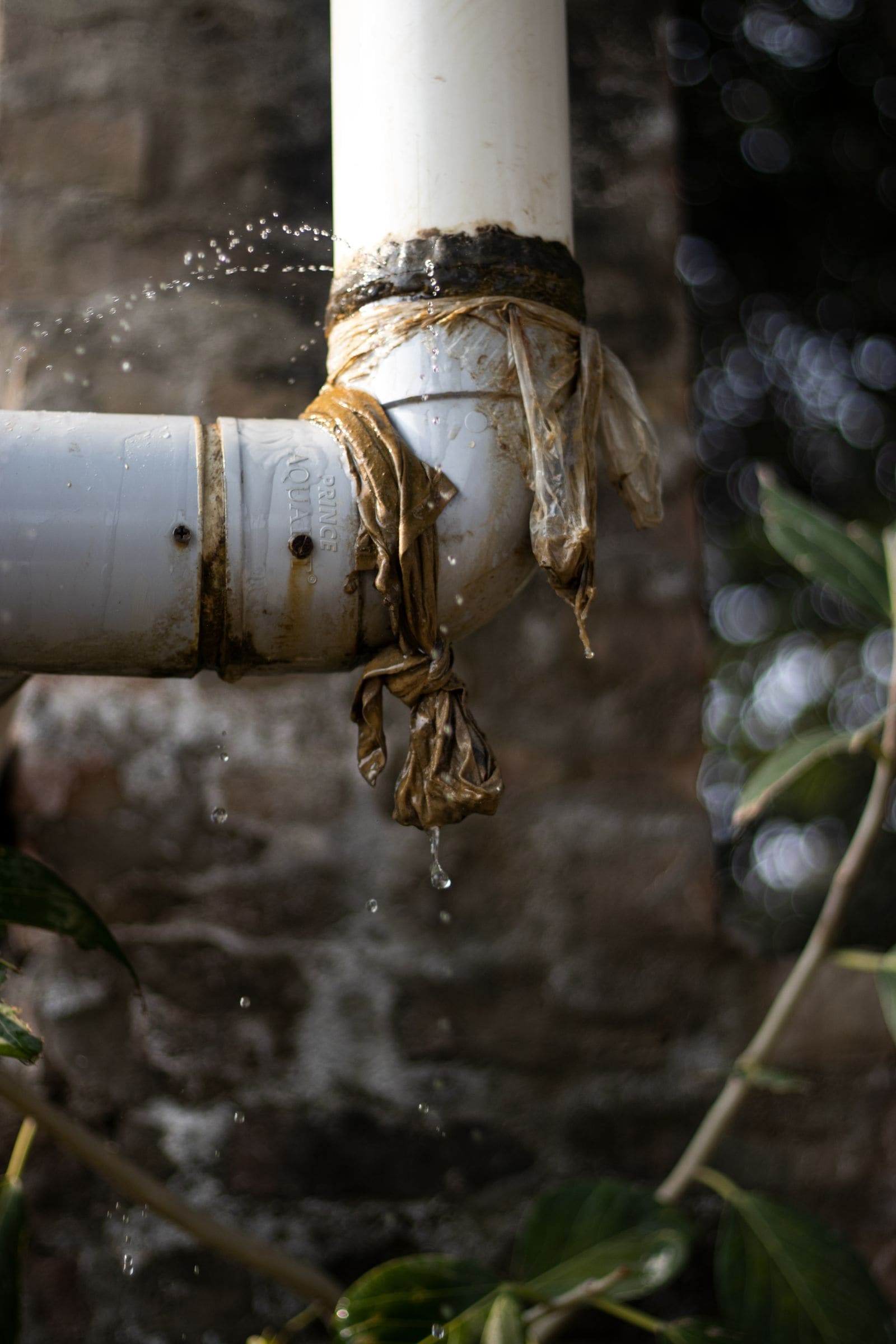 Leaking pipe wrapped in plastic as a temporary fix, dripping water